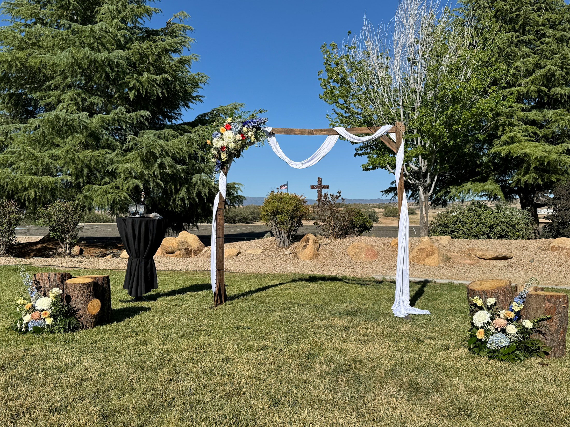 Montaje de ceremonia al aire libre con flores y tela blanca
